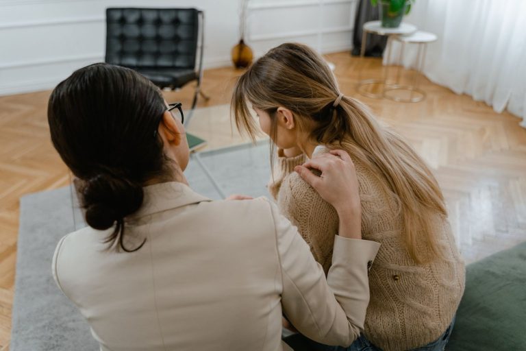O que o entorno de uma pessoa diz sobre o cuidado em saúde mental Duas mulheres sentadas em um ambiente interno, compartilhando um momento de apoio e empatia.